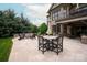 Outdoor patio with fire pit, table with umbrella, seating, and beautiful landscaping at 11000 Strike The Gold Ln, Waxhaw, NC 28173