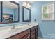 Bright bathroom with double sinks, vanity, framed mirrors, and blue walls at 111 Tilton Dr, Mooresville, NC 28115