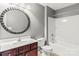 A bathroom is featured with a dark vanity with a white sink, a shower-tub, and a large decorative mirror at 111 Tilton Dr, Mooresville, NC 28115