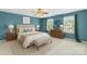This bedroom offers a calming space with soothing teal walls, plush carpeting, and updated ceiling fan at 111 Tilton Dr, Mooresville, NC 28115