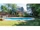 Spacious backyard featuring a swimming pool, wooden deck, and lush landscaping at 12601 Guardhouse Ct, Charlotte, NC 28262