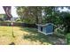 A fenced backyard with a large well maintained lawn and blue painted dog house under the mature trees at 12601 Guardhouse Ct, Charlotte, NC 28262