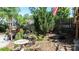 This backyard retreat features a bird bath, stone walkway, garden bed, and a charming wood fence at 12601 Guardhouse Ct, Charlotte, NC 28262