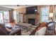 Cozy living room with stone fireplace, hardwood floors, and comfortable leather furniture at 12601 Guardhouse Ct, Charlotte, NC 28262