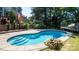 Inviting swimming pool with concrete surround and a rock fire pit, perfect for outdoor entertaining at 12601 Guardhouse Ct, Charlotte, NC 28262