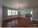 Dining room featuring hardwood floors, a decorative chandelier, large windows, and neutral wall paint at 1415 S York Rd, Gastonia, NC 28052