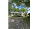 Inviting single-story home with gray siding, black shutters, and a cozy front porch, framed by lush greenery at 1415 S York Rd, Gastonia, NC 28052