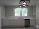 Kitchen with gray floors, white cabinets and countertops, stainless steel appliances, and a modern light fixture at 1415 S York Rd, Gastonia, NC 28052