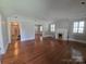 Open living room featuring hardwood floors, a decorative fireplace, large windows, and neutral paint at 1415 S York Rd, Gastonia, NC 28052
