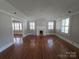Spacious living room with wood flooring, a fireplace, shutters on the windows and neutral paint at 1415 S York Rd, Gastonia, NC 28052