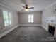 Bright living room with neutral walls, carpet flooring, fireplace and multiple windows at 1415 S York Rd, Gastonia, NC 28052