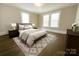 Cozy bedroom featuring two large windows, a stylish rug, and a comfortable bed with decorative pillows at 169 Freeze Nw Ave, Concord, NC 28025
