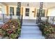 Inviting front porch with decorative railings, wooden shutters, and blossoming flowers at 169 Freeze Nw Ave, Concord, NC 28025