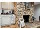 Close-up of a unique stone fireplace with decor, alongside white cabinets and stone floors at 18 Shipmaster Ct, Clover, SC 29710