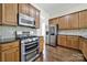 Kitchen showcasing stainless steel appliances, wooden cabinets, and hardwood floors at 1855 Second Baxter Xing, Fort Mill, SC 29708