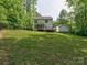 Large grassy backyard featuring a deck, screened in porch, two-story home, and separate garage at 1904 Lark Ln, Stanley, NC 28164