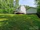 View of the back of home featuring the siding, foundation, yard, deck, and separate garage at 1904 Lark Ln, Stanley, NC 28164