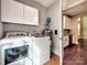 Bright laundry room with included washer, dryer and upper cabinets at 1904 Lark Ln, Stanley, NC 28164