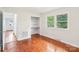 Sunlit bedroom with hardwood floors, built-in shelves, and large windows overlooking greenery at 205 Dogwood Ln, Dallas, NC 28034