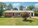 Charming single-story brick home with a well-maintained lawn and mature trees at 205 Dogwood Ln, Dallas, NC 28034