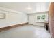 Spacious two car garage features an epoxy floor, storage shelves, window and painted brick accent wall at 205 Dogwood Ln, Dallas, NC 28034