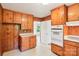 Kitchen features knotty pine cabinets, white appliances, and doorway at 205 Dogwood Ln, Dallas, NC 28034