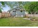 Backyard featuring a private fence, lush lawn, stone furniture and a charming blue house at 222 N Weldon St, Gastonia, NC 28052
