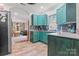 View of open kitchen with stainless appliances, dark teal cabinets, and view to living area at 222 N Weldon St, Gastonia, NC 28052
