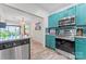 A modern kitchen boasts stainless steel appliances and vibrant teal cabinetry, enhancing its charm at 222 N Weldon St, Gastonia, NC 28052