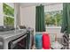 Laundry room with gray washer and dryer, bright light, and organizing baskets at 222 N Weldon St, Gastonia, NC 28052
