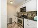 Kitchen features white cabinets, stainless steel appliances, and mosaic backsplash at 233 Northwest Dr, Davidson, NC 28036