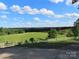 Expansive green backyard with white fencing and trees, viewed from a concrete patio on a sunny day at 2530 Sharon Rd, York, SC
