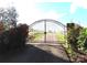 Gated entrance with blooming red roses on either side, leading to a scenic driveway and property at 2530 Sharon Rd, York, SC