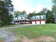 Inviting brick home with a green roof, white trim, and a spacious three-car garage on a lush, green lawn at 2530 Sharon Rd, York, SC