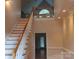 Bright foyer with staircase and balcony, featuring neutral walls, white trim, and wood flooring at 2530 Sharon Rd, York, SC