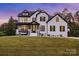 Elegant white brick home featuring black trim, a covered porch, and a well-manicured lawn at 2854 Harlinsdale Dr, Rock Hill, SC 29732