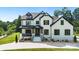 Elegant two-story home with a white brick exterior, black trim, well-manicured lawn and beautiful landscaping at 2854 Harlinsdale Dr, Rock Hill, SC 29732