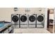 Laundry room featuring four Samsung washing machines with drawers and storage shelves at 2854 Harlinsdale Dr, Rock Hill, SC 29732