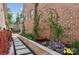 Charming side yard with a stone pathway, lush garden beds, and a decorative wrought-iron arch at 3006 Portico Pl # 37, Fort Mill, SC 29715