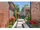 Tranquil side yard featuring decorative metal screens, lush plantings, and a covered patio in the background at 3006 Portico Pl # 37, Fort Mill, SC 29715