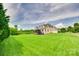A sprawling backyard extending from the house, highlighted by a lush lawn and mature trees, creating a serene setting at 308 Hollister Estates Dr, Waxhaw, NC 28173