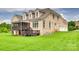 Expansive backyard showcasing the home's brick facade, screened-in porch, and lush green lawn at 308 Hollister Estates Dr, Waxhaw, NC 28173