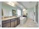 Bright bathroom featuring a soaking tub, granite countertop vanity, and a glass shower at 308 Hollister Estates Dr, Waxhaw, NC 28173