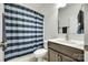 Bathroom featuring a shower with blue striped curtain, toilet, and sink with storage at 308 Hollister Estates Dr, Waxhaw, NC 28173