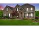 Charming two-story brick home with stone accents, covered porch, and mature landscaping at 308 Hollister Estates Dr, Waxhaw, NC 28173