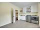 Bright laundry room with white cabinetry, folding counter, and modern appliances at 308 Hollister Estates Dr, Waxhaw, NC 28173