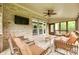 Relaxing screened-in patio featuring comfortable seating, a ceiling fan, and a mounted TV for outdoor entertainment at 308 Hollister Estates Dr, Waxhaw, NC 28173