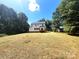 Spacious backyard with a wooden deck, white siding, and green grass at 3114 Ansonville Rd, Marshville, NC 28103
