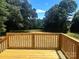 View from wooden back deck overlooking a spacious green backyard with many shade trees at 3114 Ansonville Rd, Marshville, NC 28103
