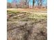 An undeveloped lot featuring a grassy area, partially covered with fallen leaves, and scattered mature trees at 3114 Ansonville Rd, Marshville, NC 28103